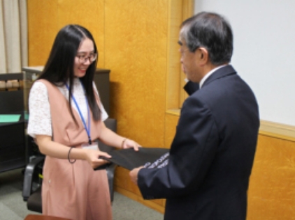President Ueno hands gifts to students.